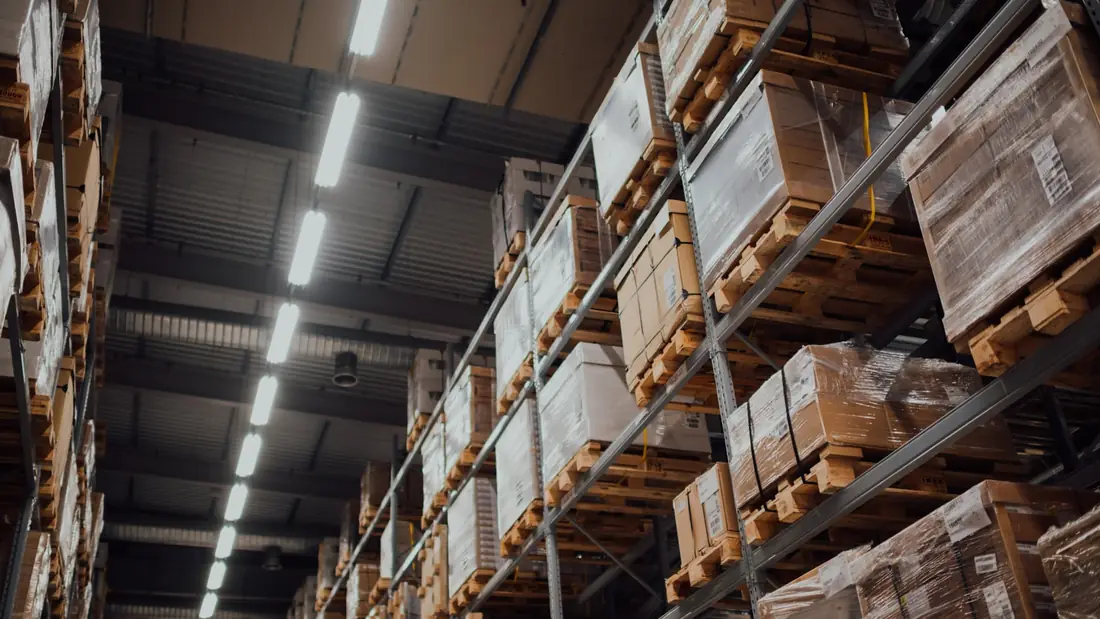 LED strip lights above warehouse shelving stacked with pallets