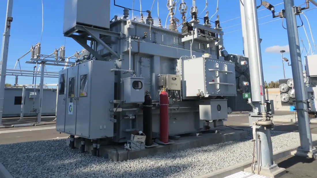 Large electrical transformer and switchgear in a fenced power yard