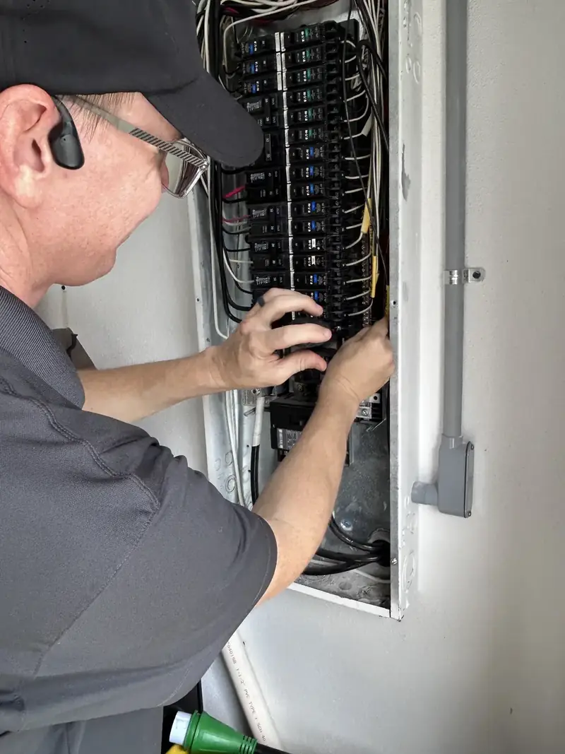 Kincaid Electric electrician working on breakers in an electrical panel