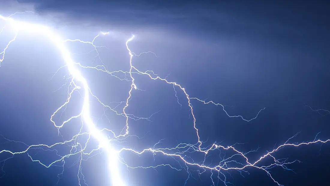 Lightning bolts across a stormy night sky
