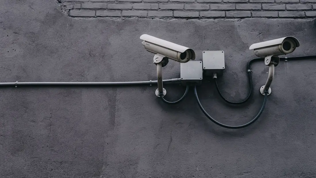 Two security cameras mounted on a concrete wall